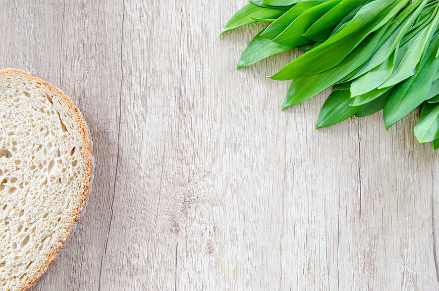 Fresh Ramson Leaves and Sourdough Bread on Wooden Background
