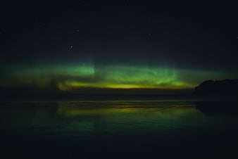 Green Aurora Borealis Reflecting on Calm Ocean Water at Night
