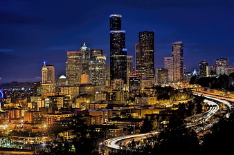 Seattle skyline at night with light trails on highway