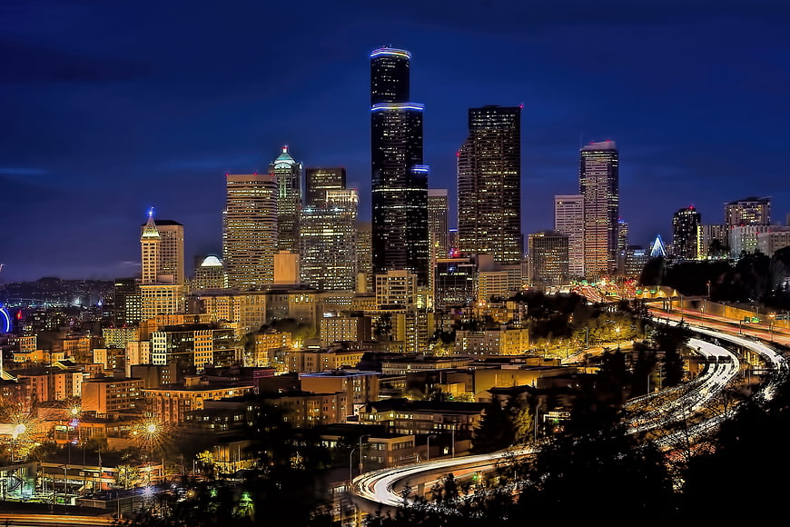 Seattle skyline at night with light trails on highway