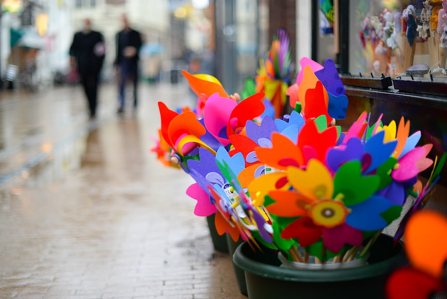 Colorful plastic pinwheels on a rainy city street