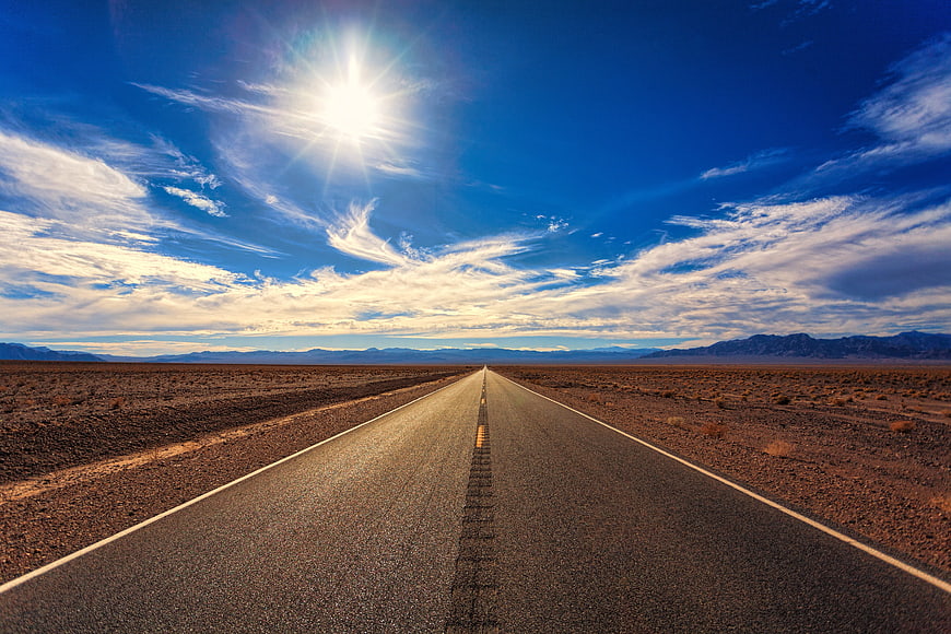 Endless Desert Highway Under Bright Blue Sky