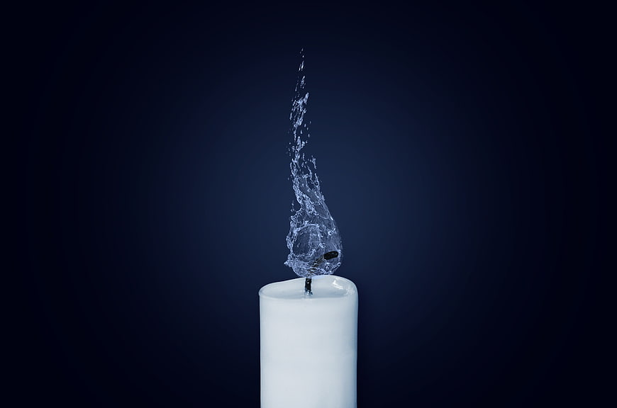 Surreal Water Flame on White Candle Against Dark Blue Background