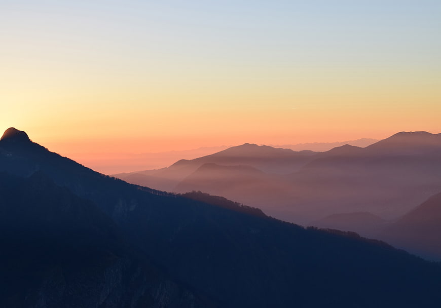Serene Mountain Silhouette at Sunset with Misty Layers