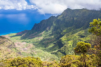 Lush Green Mountain Ridge Overlooking Blue Ocean Coastline