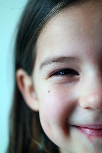 Close-up of a smiling child's eye and cheek