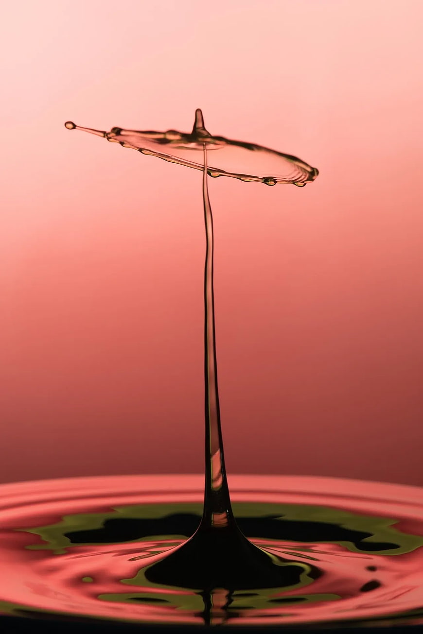 Abstract Water Drop Splash Crown on Pink Background