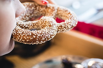 Close-up of woman eating sesame seed pretzel