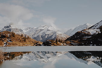 Snowy mountain peaks reflected in a calm alpine lake
