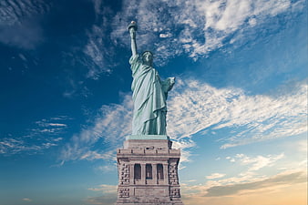 Statue of Liberty against dramatic blue sky with clouds