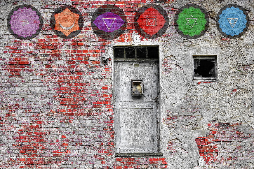 Colorful Chakra Symbols Painted on Weathered Brick Wall