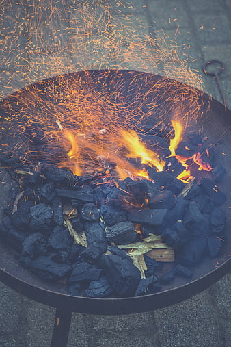 Charcoal fire with sparks in a metal grill