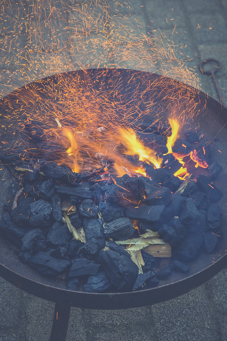 Charcoal fire with sparks in a metal grill
