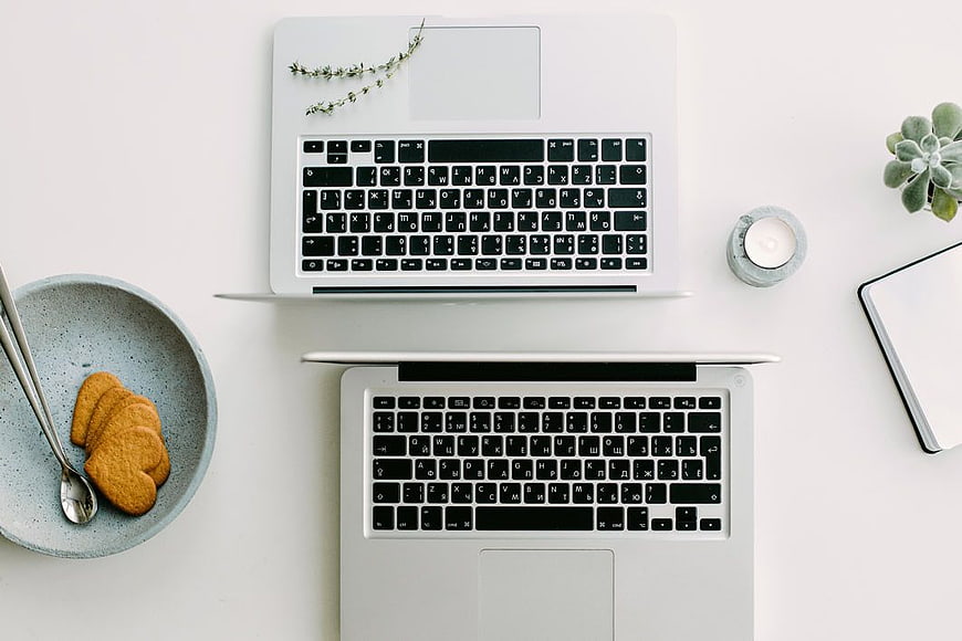 Minimalist Workspace with Two Laptops and Cookies