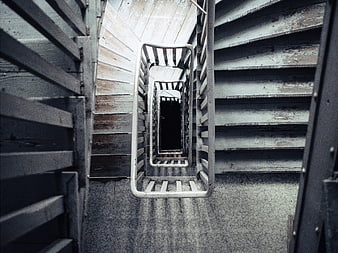 Top-down view of weathered industrial spiral staircase