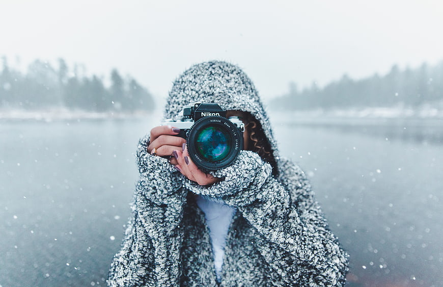 Woman Photographer Taking Photo in Snowy Winter Landscape
