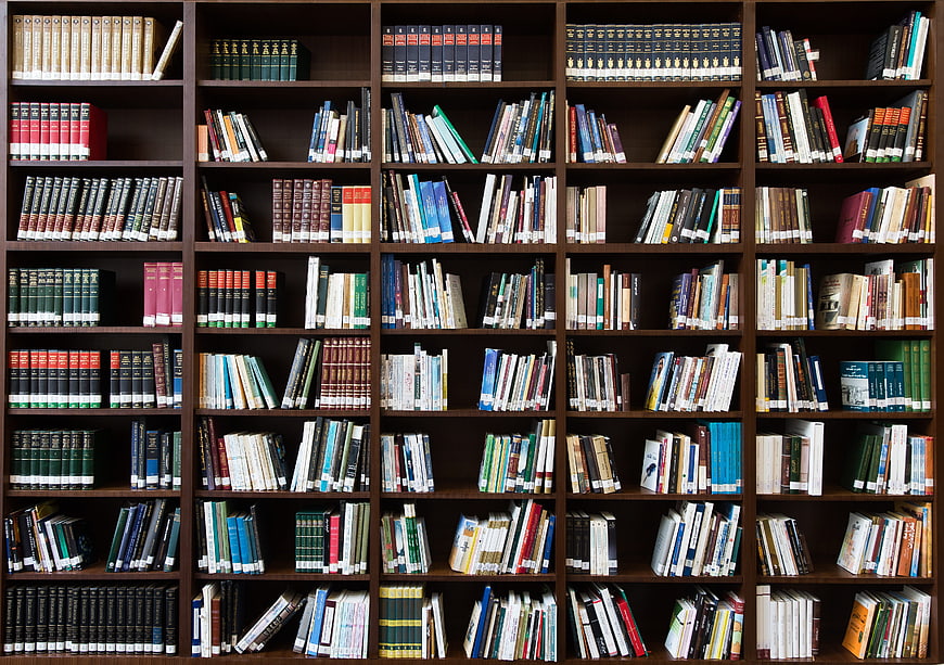 Full wooden bookshelf filled with colorful books in a library