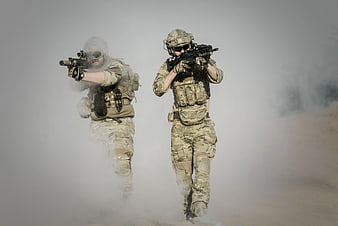 Two soldiers in tactical gear advancing through smoke
