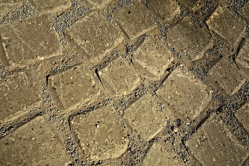 Textured gray stone blocks with gravel gaps background