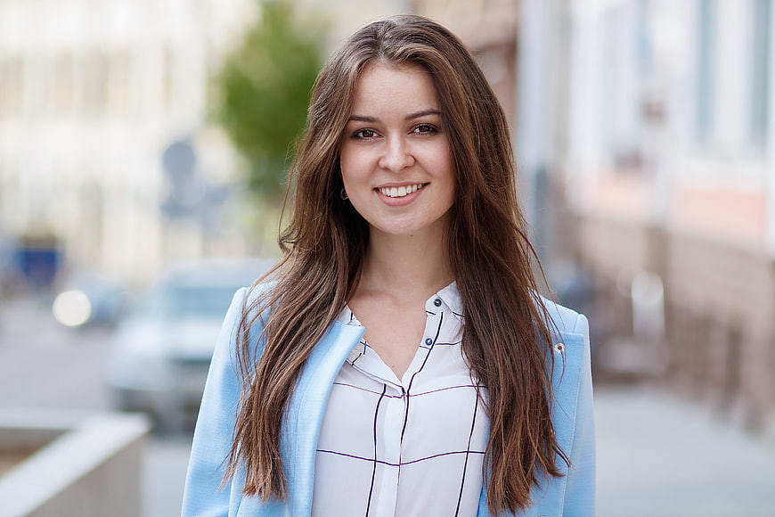 Portrait of smiling young woman in blue blazer outdoors