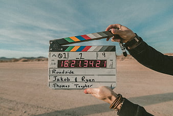 Film clapperboard held in desert landscape