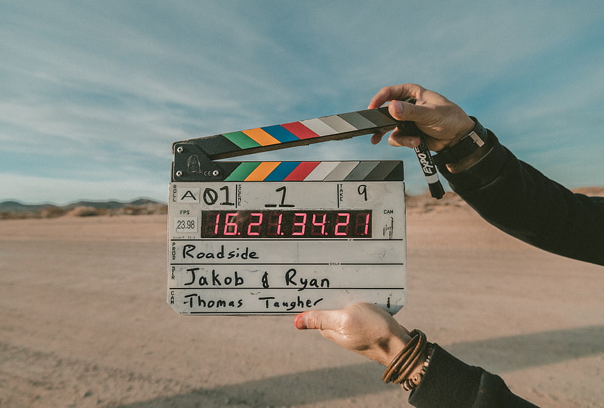 Film clapperboard held in desert landscape