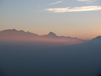 Serene Mountain Silhouette Above Sea of Clouds at Sunset