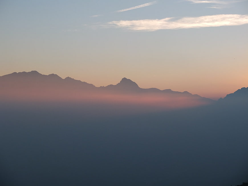 Serene Mountain Silhouette Above Sea of Clouds at Sunset
