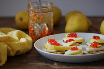 Rustic pear and cheese appetizers with red jam on crackers