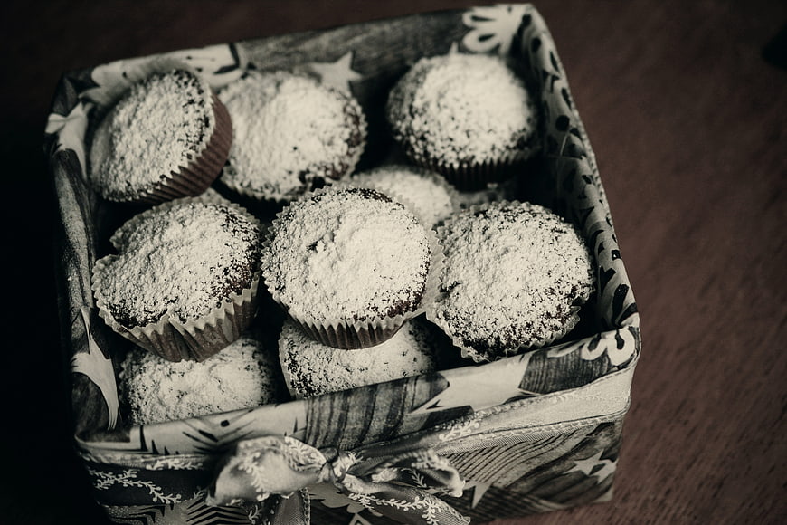 Box of chocolate muffins dusted with powdered sugar