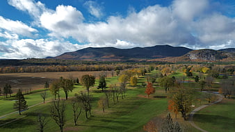 Aerial View of Autumn Park with Mountains and Cloudy Sky