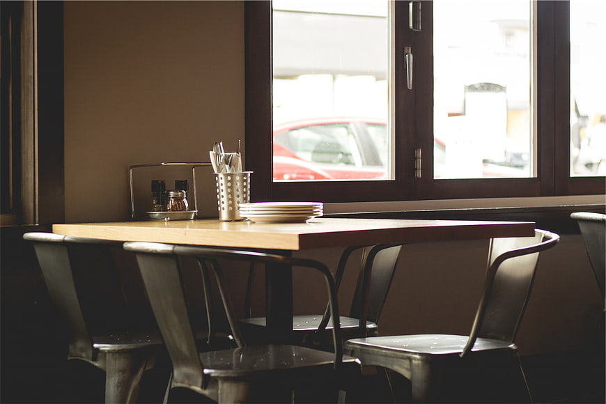 Empty wooden table and metal chairs in a cafe interior