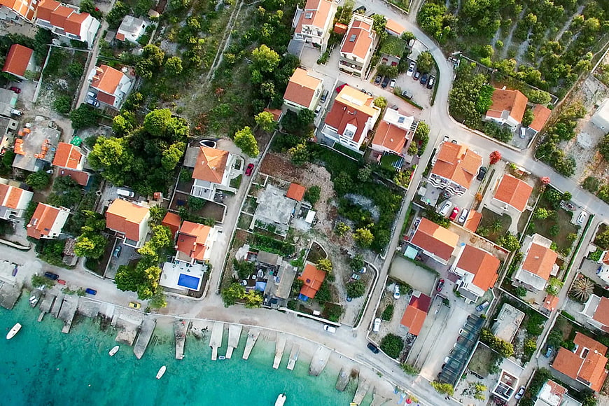 Aerial View of Coastal Village with Red Roofs and Turquoise Sea