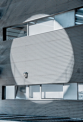 Modern building facade with circular sunlight shadow pattern