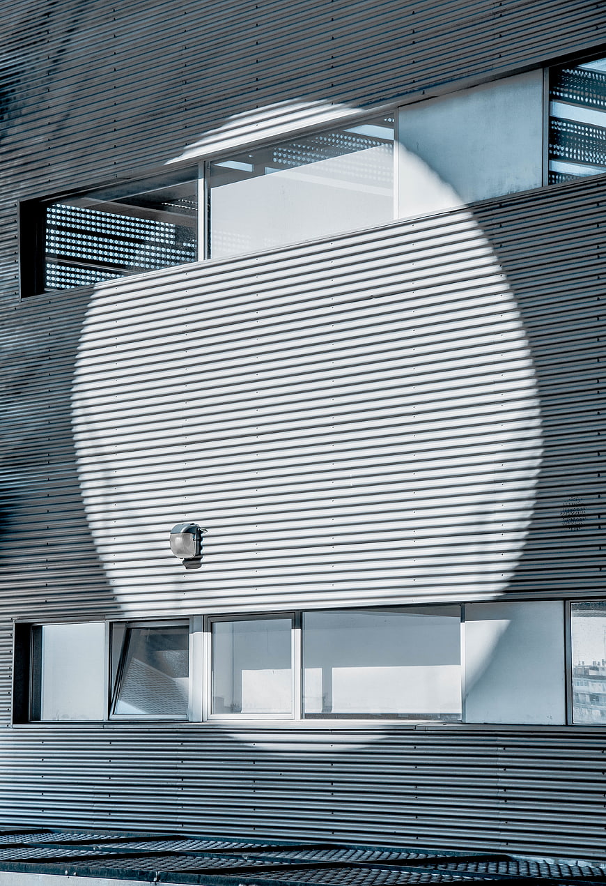 Modern building facade with circular sunlight shadow pattern