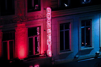 Neon Brasserie Sign on Building Facade at Night