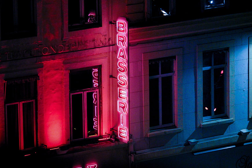 Neon Brasserie Sign on Building Facade at Night