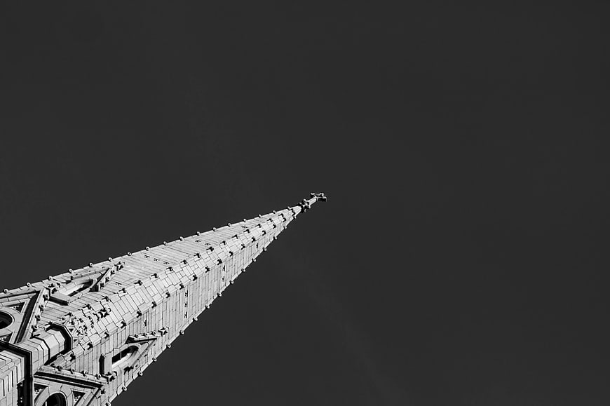 Low angle black and white photo of gothic cathedral spire
