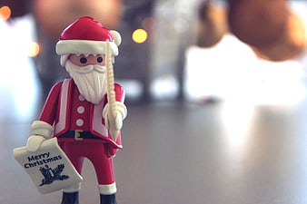 Close-up of Santa Claus toy holding Merry Christmas card