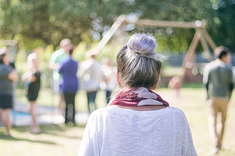 Back view of woman with purple hair bun at outdoor gathering