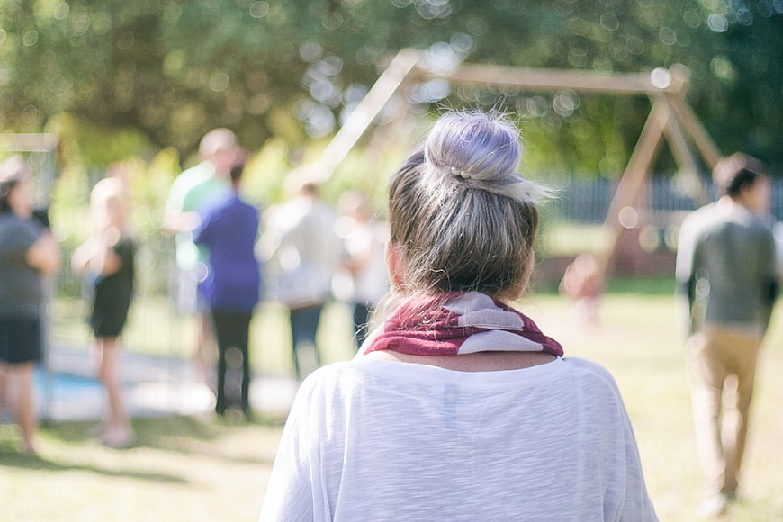 Back view of woman with purple hair bun at outdoor gathering