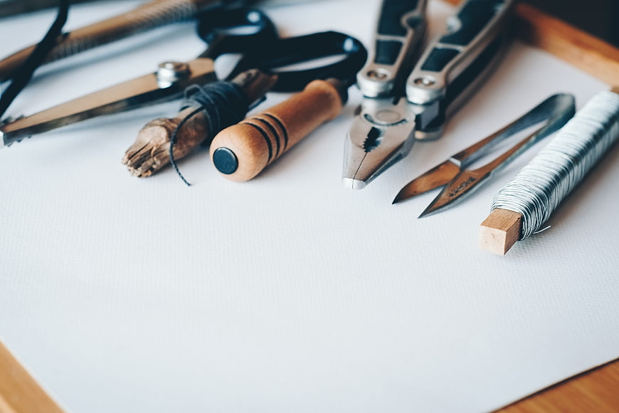 Jewelry making tools and wire on white background