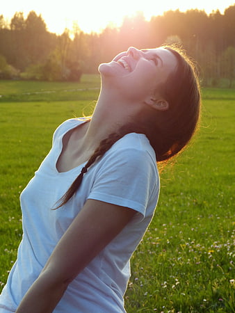 Happy Woman Laughing in Meadow at Sunset