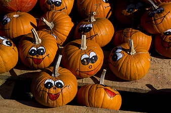 Hand-painted smiling pumpkins on wooden shelves for Halloween