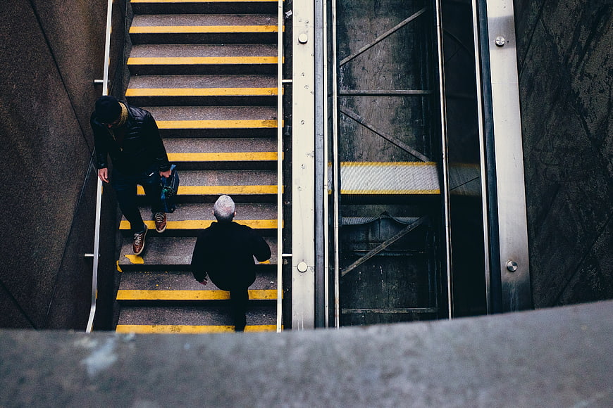 High angle view of two men descending subway stairs