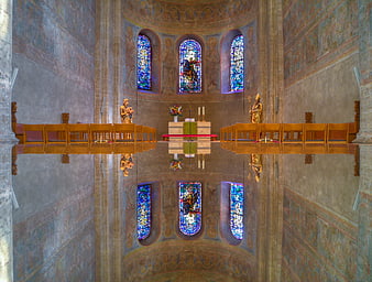 Symmetrical church interior with stained glass and altar reflection