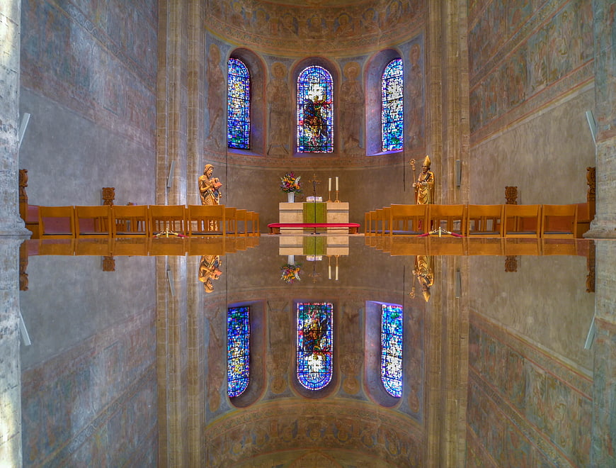 Symmetrical church interior with stained glass and altar reflection