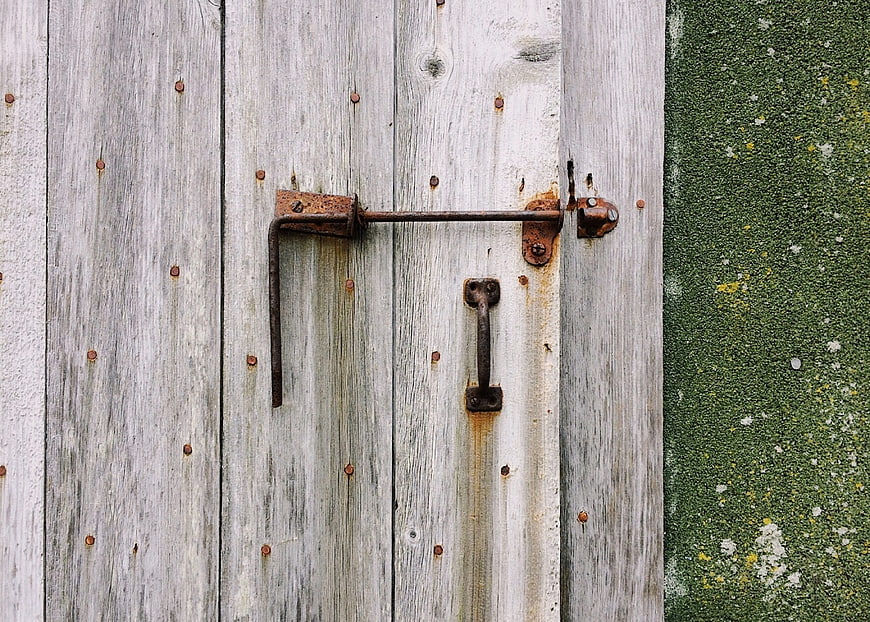 Weathered Wooden Door with Rusty Metal Latch and Handle