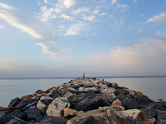 Rocky Jetty Leading to Lighthouse at Sunrise