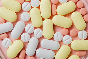 Assorted Colorful Pills and Tablets on Pink Background
